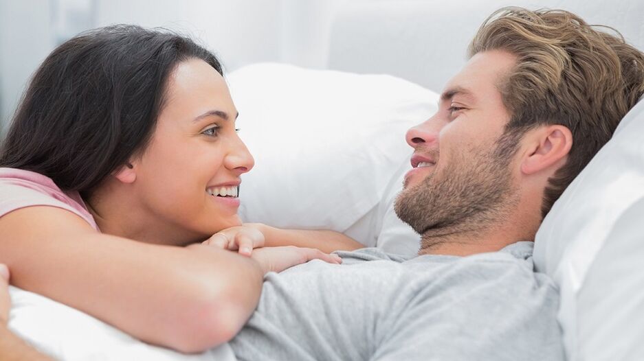 Glückliche Frau mit Mann im Bett